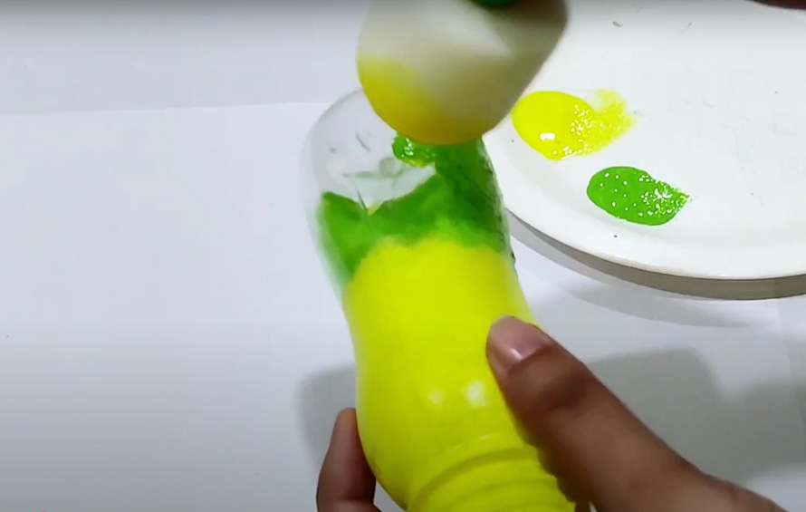 Hand painting on plastic bottles with acrylic paints, brushes, tape, and clear sealant.