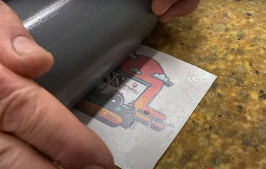 Use heat transfer paper, a printer, and a heat press to print designs on plastic bottles through DIY methods
